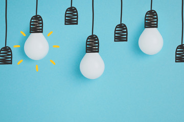close up view of white lamps pretending hanging on lamp holders isolated on blue