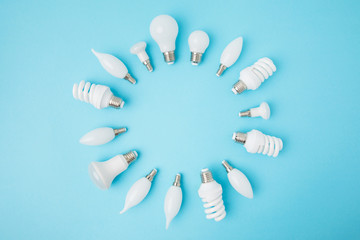 top view of different white lamps arranged in circle isolated on blue