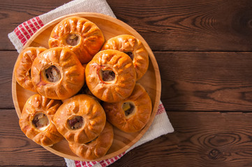 Group of individual pies with meat and potato - vak balish. Tatar traditional pies. Wooden background. Top view.