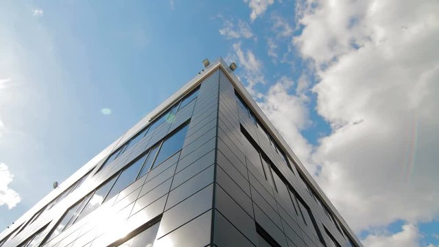 Timelapse of clouds reflected in mirrored facets of modern office building
