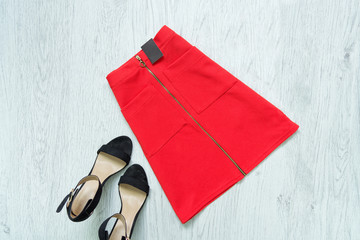 Red skirt with tag and black shoes. Fashionable concept.