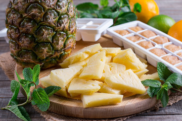 Fresh and frozen pineapple on a cutting board