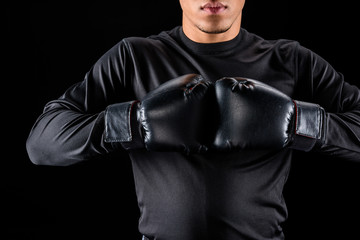 Cropped shot of African American boxer in black gloves isolated on black