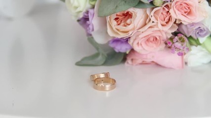 Engagement rings and wedding bouquet of flowers