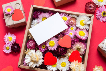 Valentine day gift, flowers, name card and boxes on red background