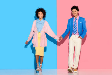 Naklejka premium happey couple holding hands on pink and blue background