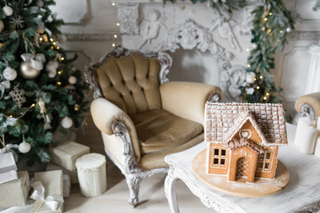 Homemade gingerbread house on background room decorated for Christmas.