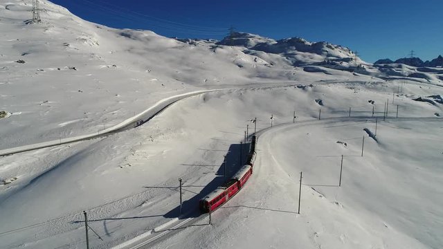 Bernina express on Bernina Pass. Winter season, red train and snow