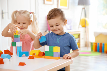 Cute little children playing with blocks at home