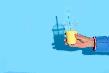 Cropped shot of african american man holding glass of juice on blue background