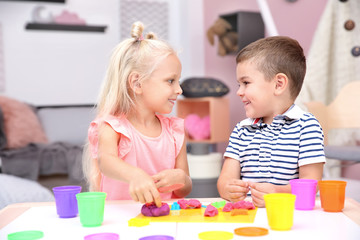 Obraz na płótnie Canvas Cute little children modeling from playdough at home