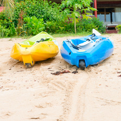 Two bright empty canoe at sand beach