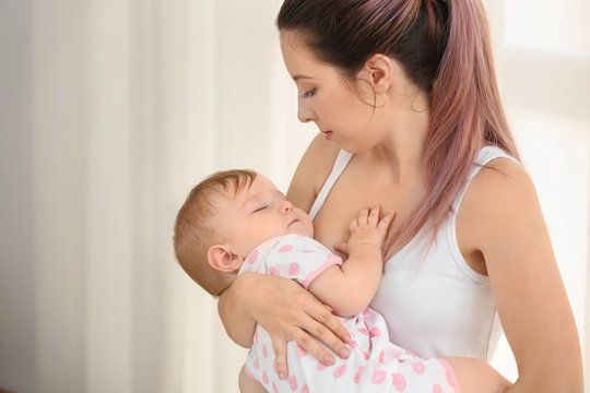 Young mother lulling her baby at home
