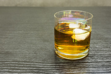 A glass of whiskey and ice.
