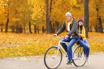 Fototapeta na wymiar Young couple riding bicycle in park
