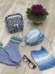 Knitted socks and scarf on a wooden background. 