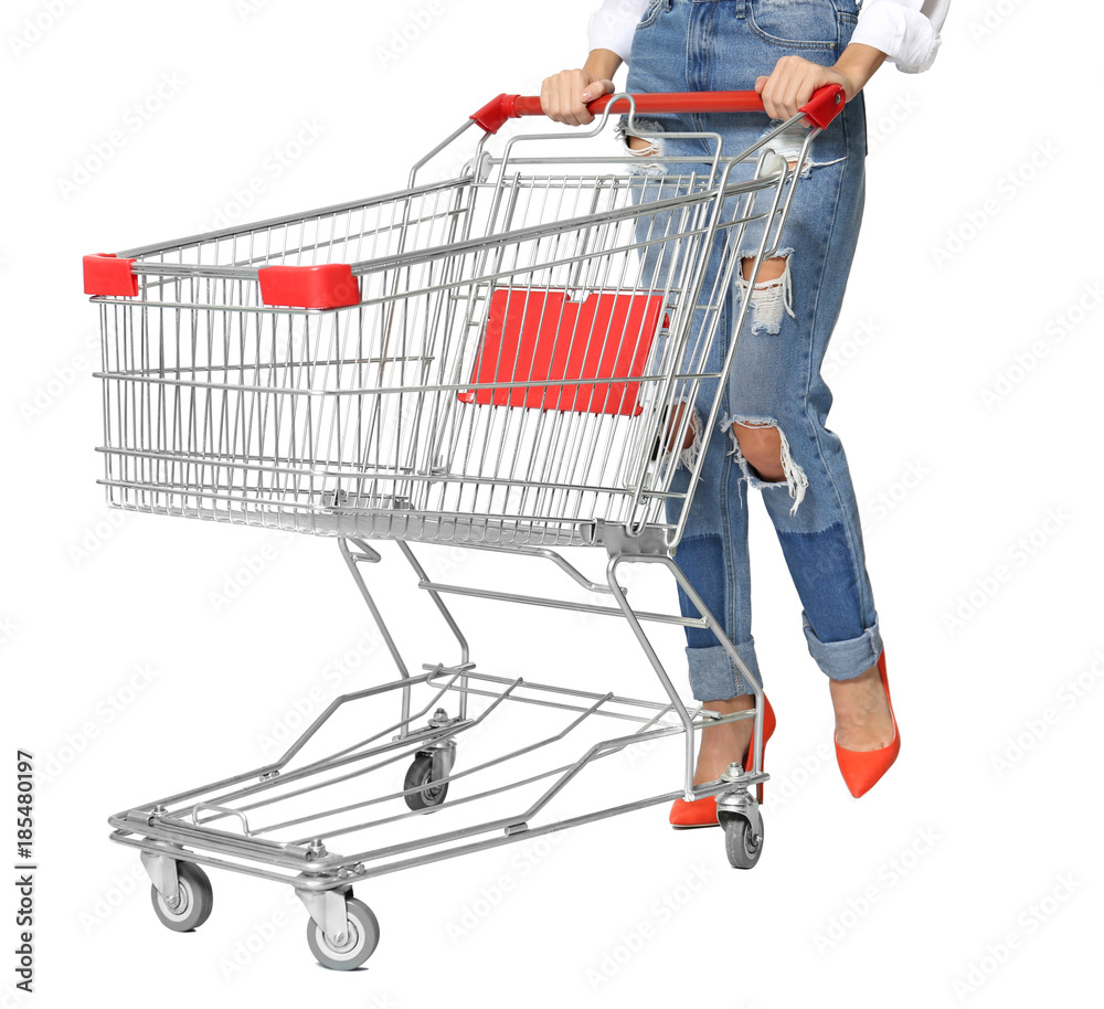 Wall mural young woman with empty shopping cart on white background