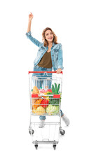Young woman with full shopping cart on white background
