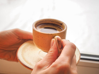 Winter coffee. Cup of black coffee at the window.
