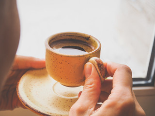 Winter coffee. Cup of black coffee at the window.
