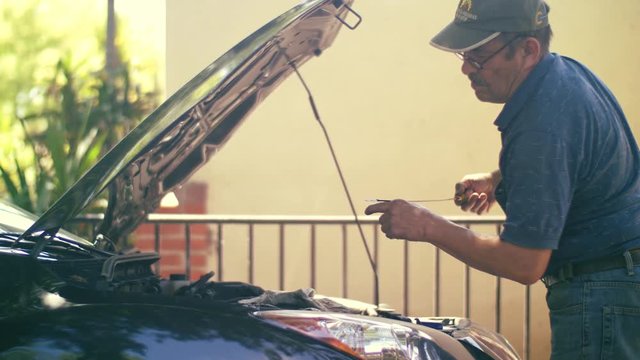 Mechanic Checking Oil Level. Car Oil Change In Driveway. 4K UHD, Slow Motion.