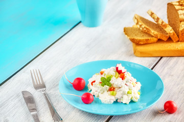Homemade breakfast set, cottage cheese with radish on a blue plate, space for text.