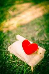 red heart on wooden bench with dramatic tone