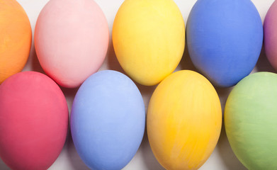 Easter composition with colored eggs on wooden white background