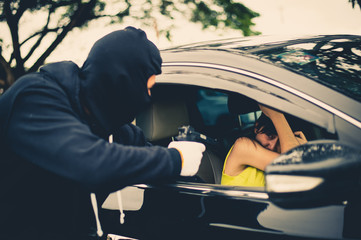 Criminal or Bandit wear black mask use gun point to woman in black car at the parking trying to rob...