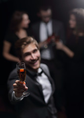 stylish young man raising his glass in a toast