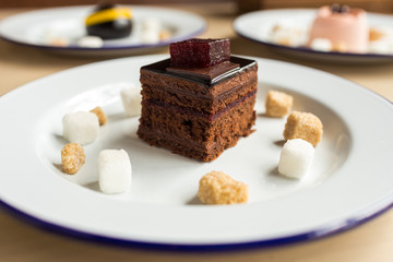 Variety of desserts on the table with white plates and marshmallows. Cherry, chocolates