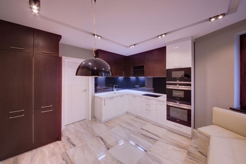 White kitchen with dark cases and a black apron