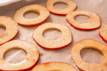 Apple slices prepared for making chips on parchment