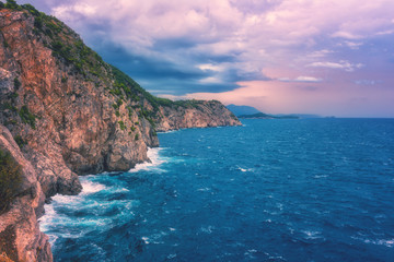 Amazing sunset seascape during a storm, wild mediterranean sea coast with waves breaking against rocks, Dubrovnik, Croatia