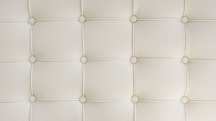  Symmetrical pattern formed by round buttons tightly tufted in a fashionable upholstery style
