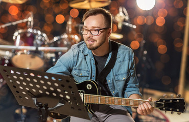 musician playing guitar at studio over lights