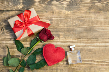 Valentine's day background with love gift, red roses, perfume and heart shapes. View from above. Copy space. Flat lay.