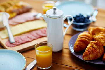 coffee pot, juice and food on table at breakfast
