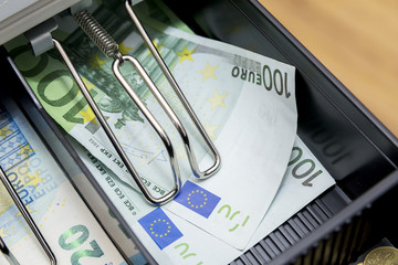 Cash register with coins and paper money