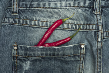 Peppers on blue jeans fabric background.