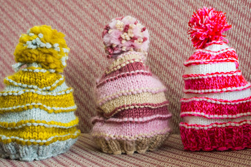 Close-up of hand-made, two-hooked, winter hat in modern colors, rose ash and beige. Shallow depth of focus. Concept hobby.