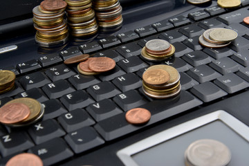 Coins on a laptop isolated on white background