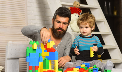 Dad and kid build of plastic blocks