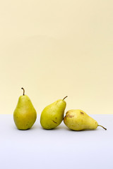 Three ripe pears on a colored background