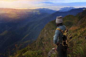 Fototapeta na wymiar A traveler on top of mountain, he standing on the rock watching a nice sunrise