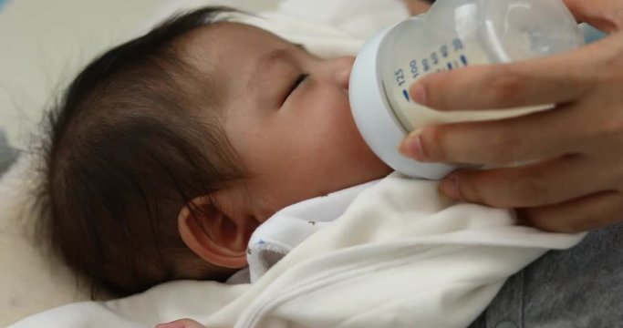 baby sucking milk from bottle