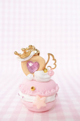 Pink macaron cookies on isolated pink background. Pink princess macaroon is wearing golden crown and wing. Sweet love and Valentine's present concept.