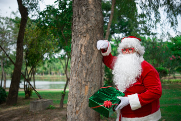 Santa claus with gift box in the forest,Thailand people,Sent happiness for children,Merry christmas,Welcome to winter