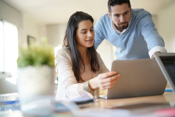 Colleagues in office working on laptop computer