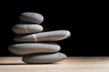 stack of five stones on black background
